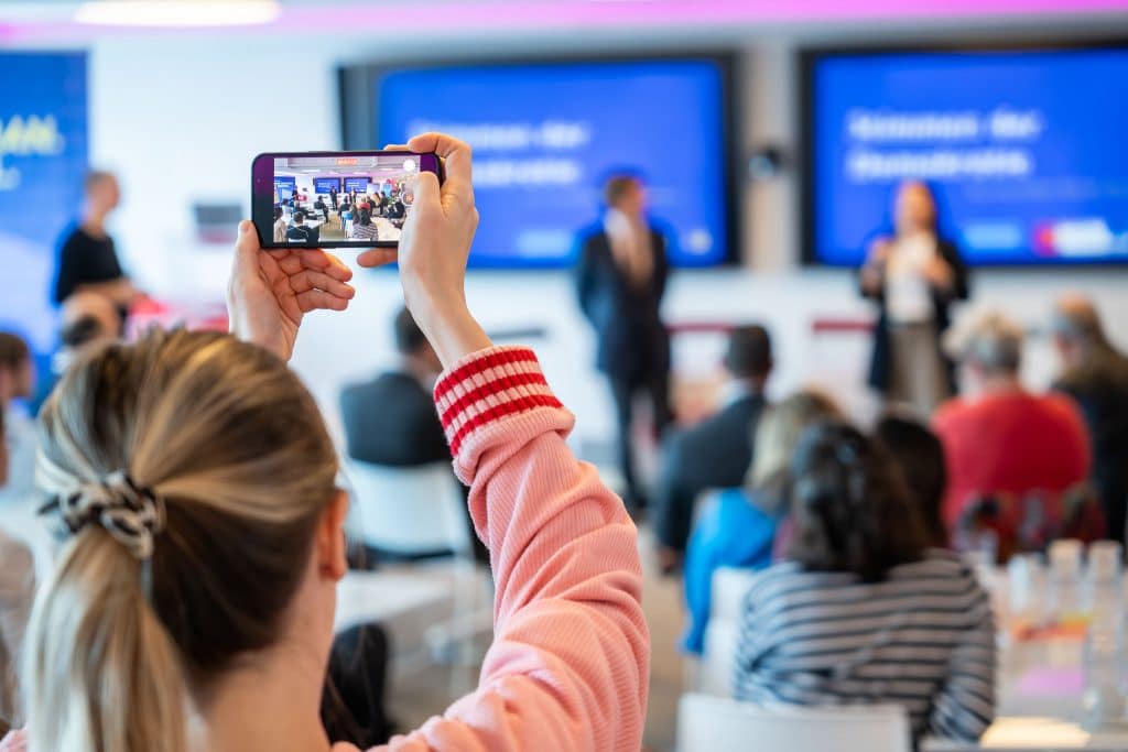 Eine Frau fotografiert bei den Digital Days die Bühne