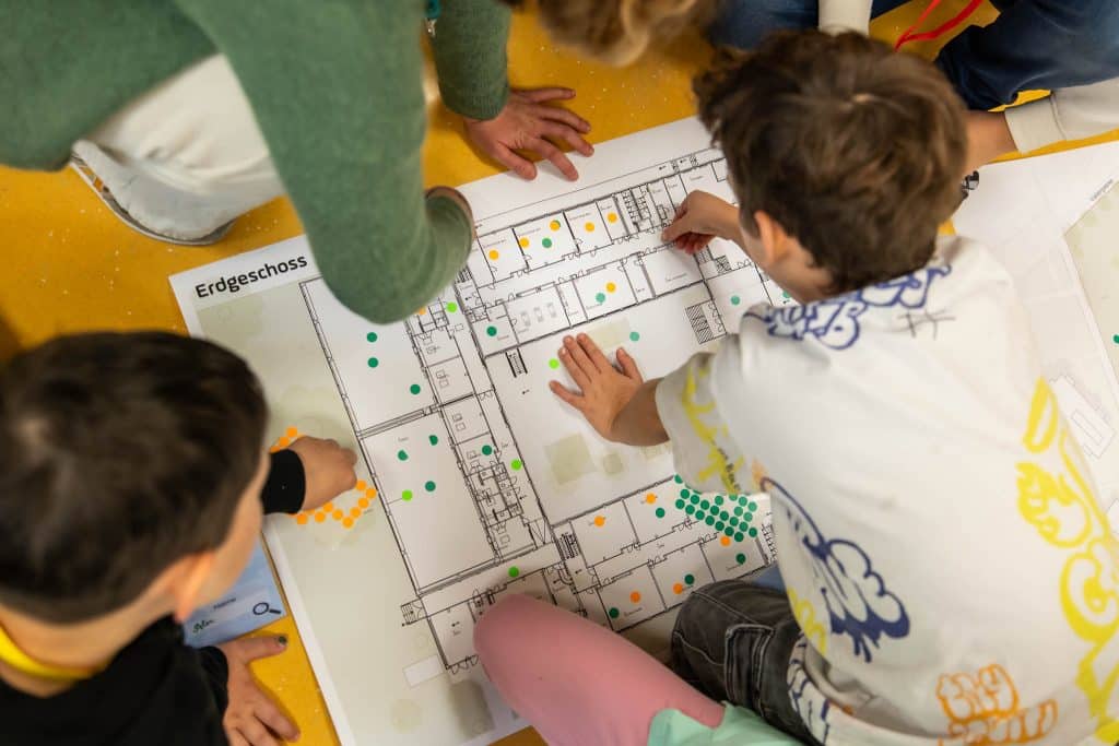 Schüler und Schülerinnen vor einem Bauplan des Gebäudes