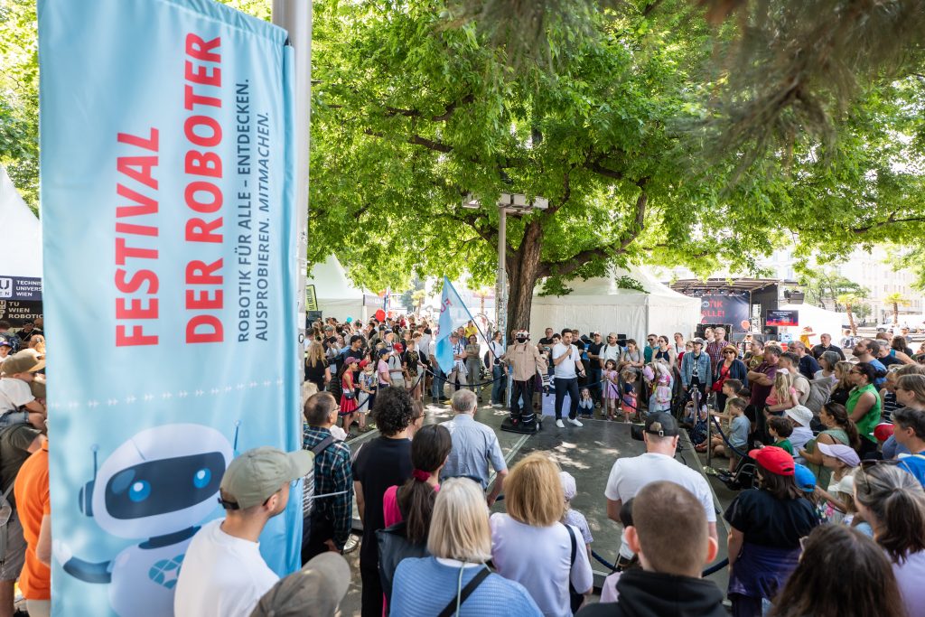 Menschenmenge bei einer Live-Demo mit einem humanoiden Roboter